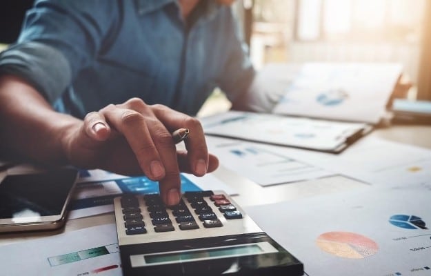 a man reading checklist and touching the calculator us